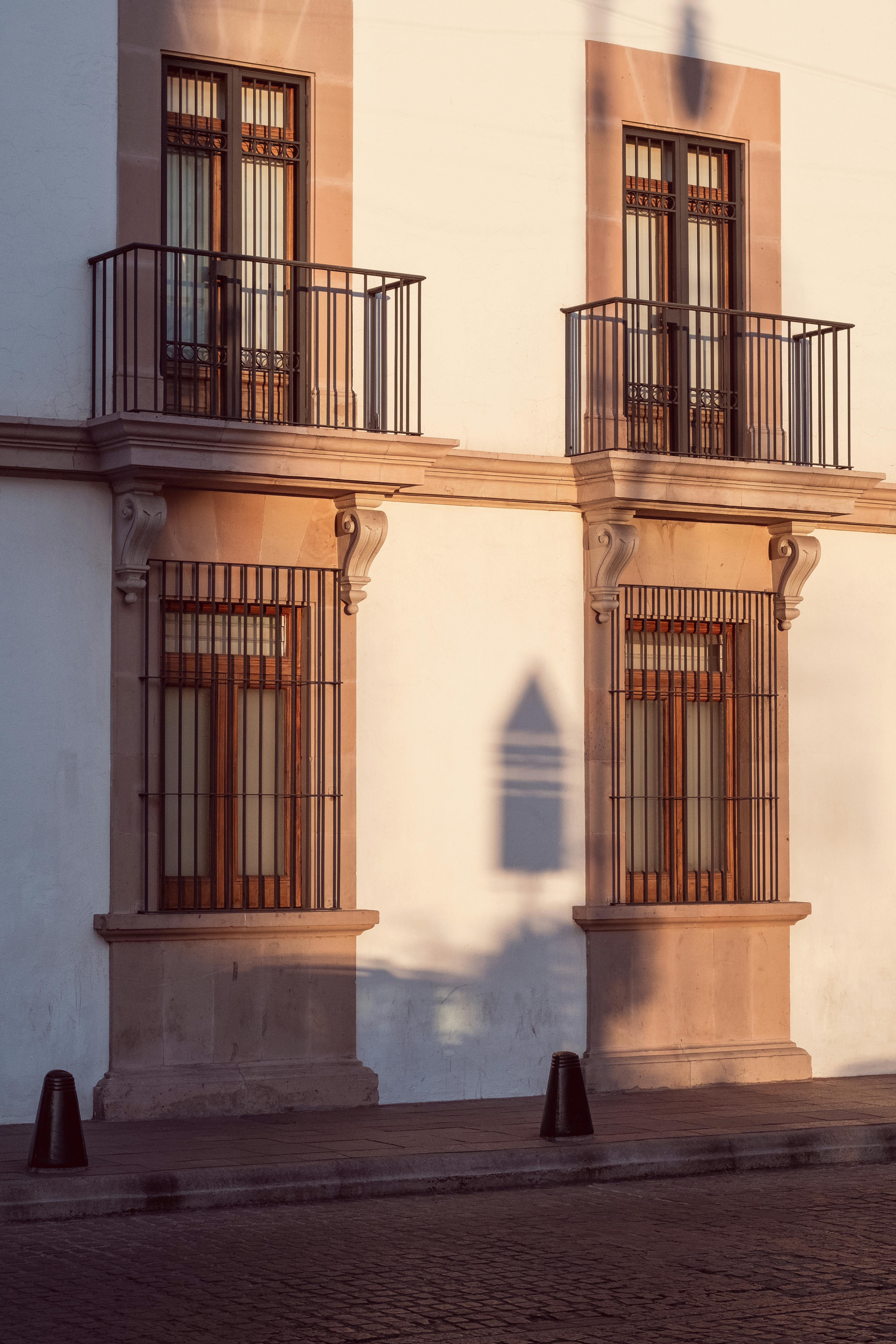Sunset lighting on stylish building façade with balconies and shadow play.