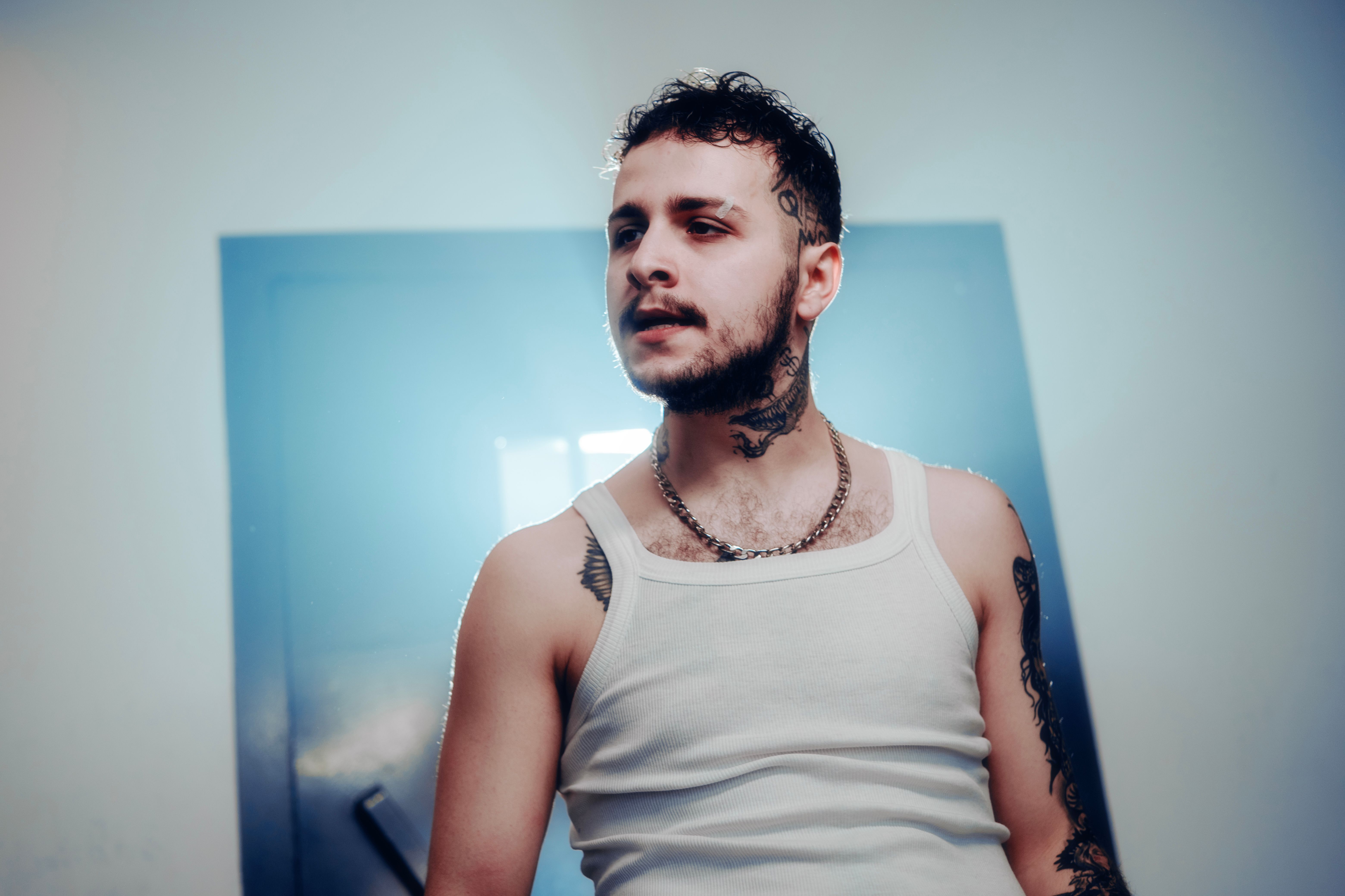 Homme portant fièrement un tatouage temporaire sur le cou, style urbain et fashion.