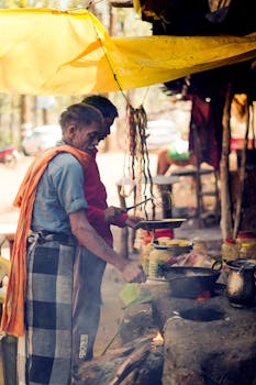 Two men cooking at an outdoor street food stall in Mainpat, India.