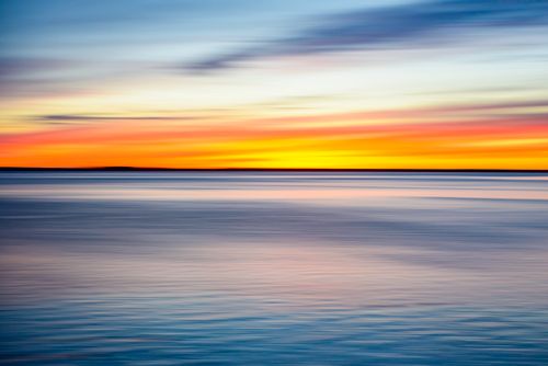 Free Stunning sunset casting vivid colors over the calm ocean in Bay City, Oregon. Stock Photo