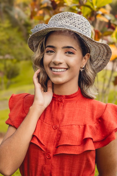 A beautiful young woman in a red dress and hat