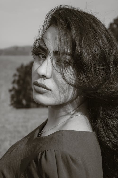 A woman with long hair is posing for a black and white photo