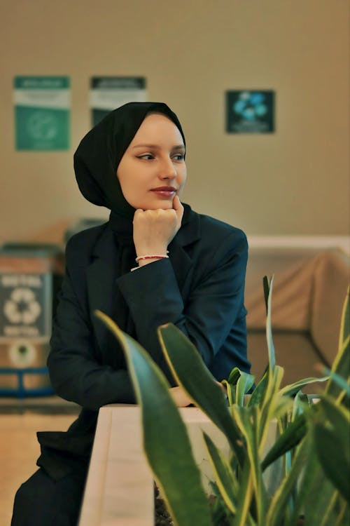 A woman in a hijab sitting at a table