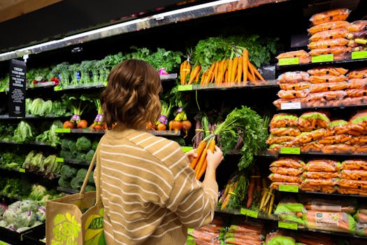 A woman chooses fresh organic carrots from a supermarket shelf. Ideal for grocery shopping themes.