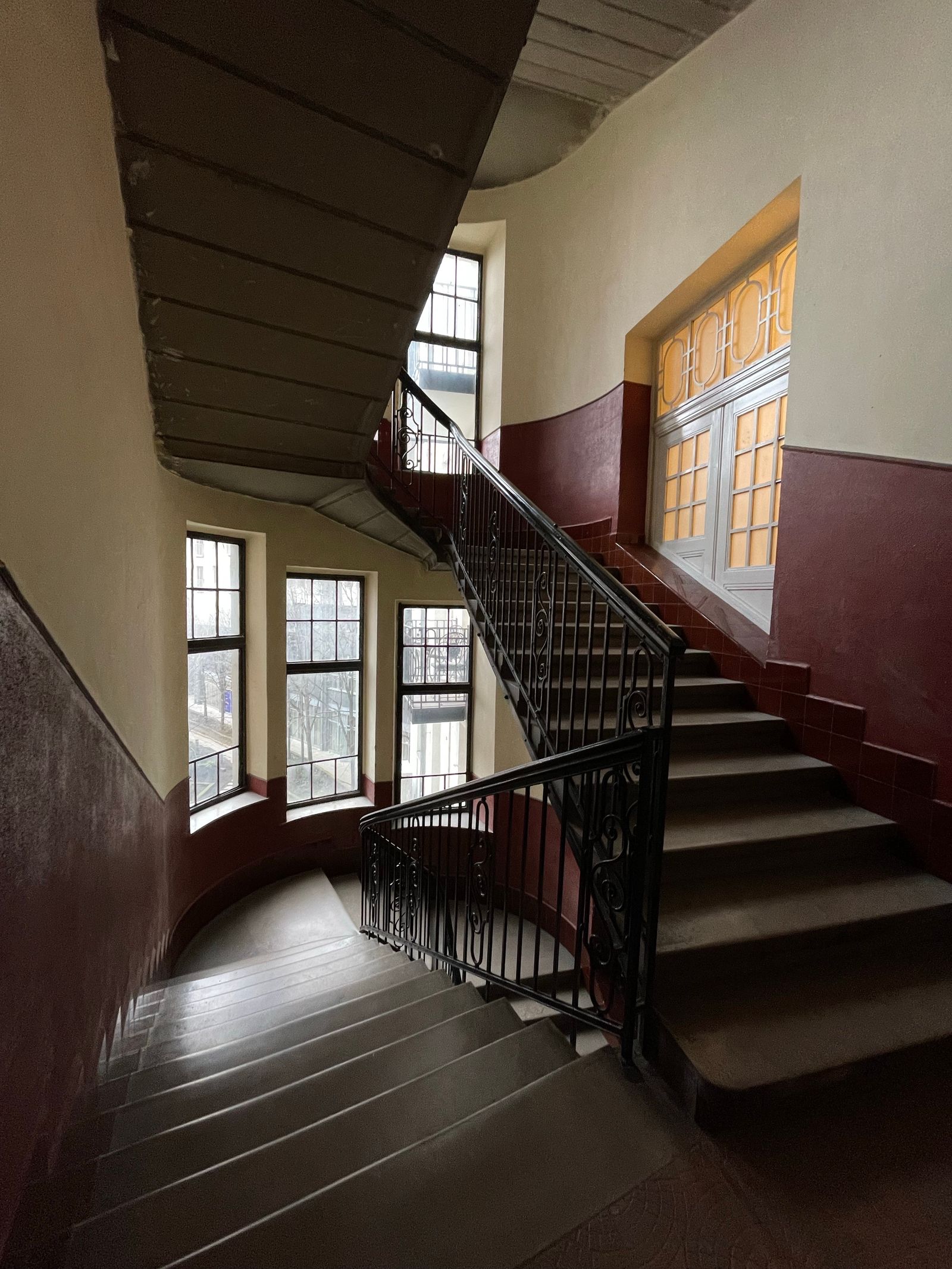 Cage d'escalier de petite copropriété, cahier de passage affiché près des boîtes aux lettres