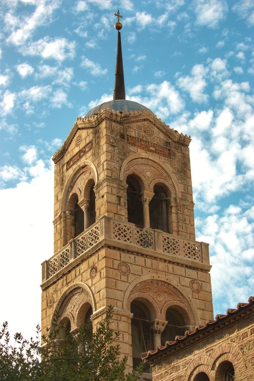 Free A close-up of a historic church tower with intricate details against a cloud-dappled sky. Stock Photo