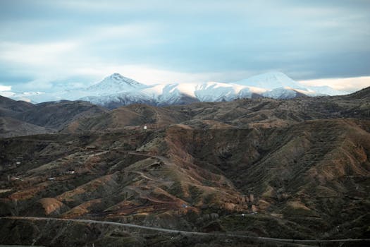 Scenic view of snow-capped mountains in Palu, Elazığ, Türkiye, under a cloudy winter sky.