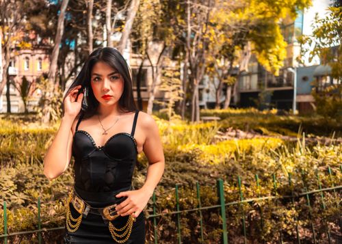Free Stylish woman posing in a park in Ciudad de México, wearing a fashionable black dress. Stock Photo