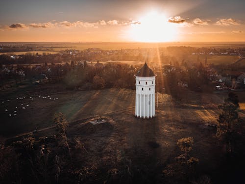 An aerial view of a church tower in the middle of a field