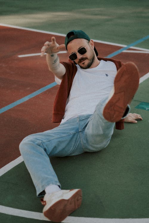 A man laying down on a basketball court with his hands up