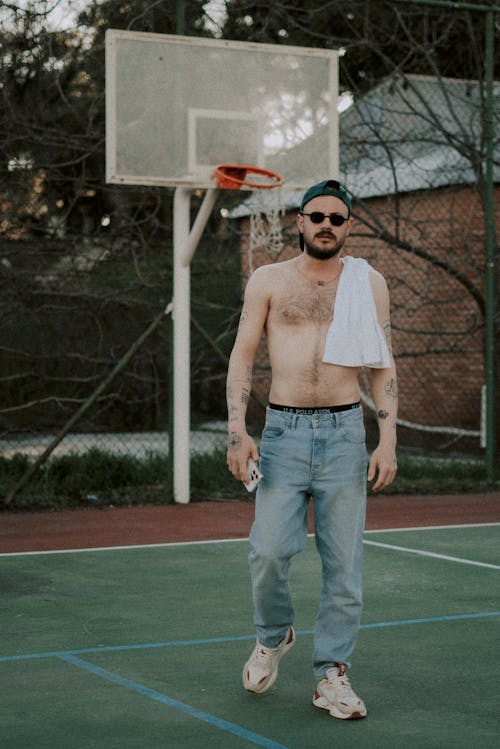 A shirtless man standing on a basketball court