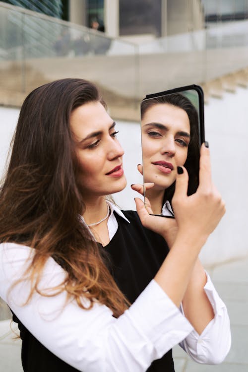 A woman is looking at herself in a mirror