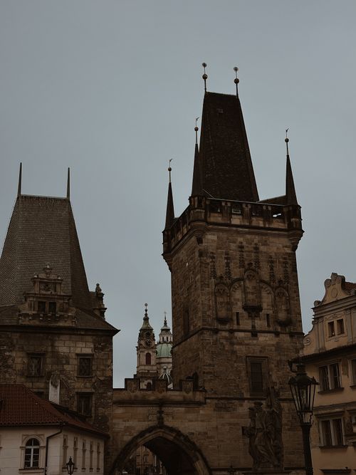 Free Moody view of Prague's Charles Bridge towers under an overcast sky, showcasing Gothic design. Stock Photo