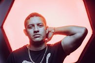 一幅以戏剧性红色为背景的肖像，展现了一位自信男士的风格与态度