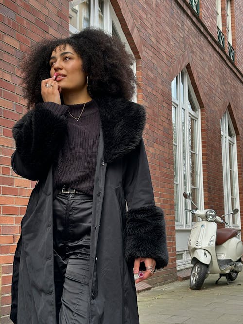 A woman in black pants and a fur coat