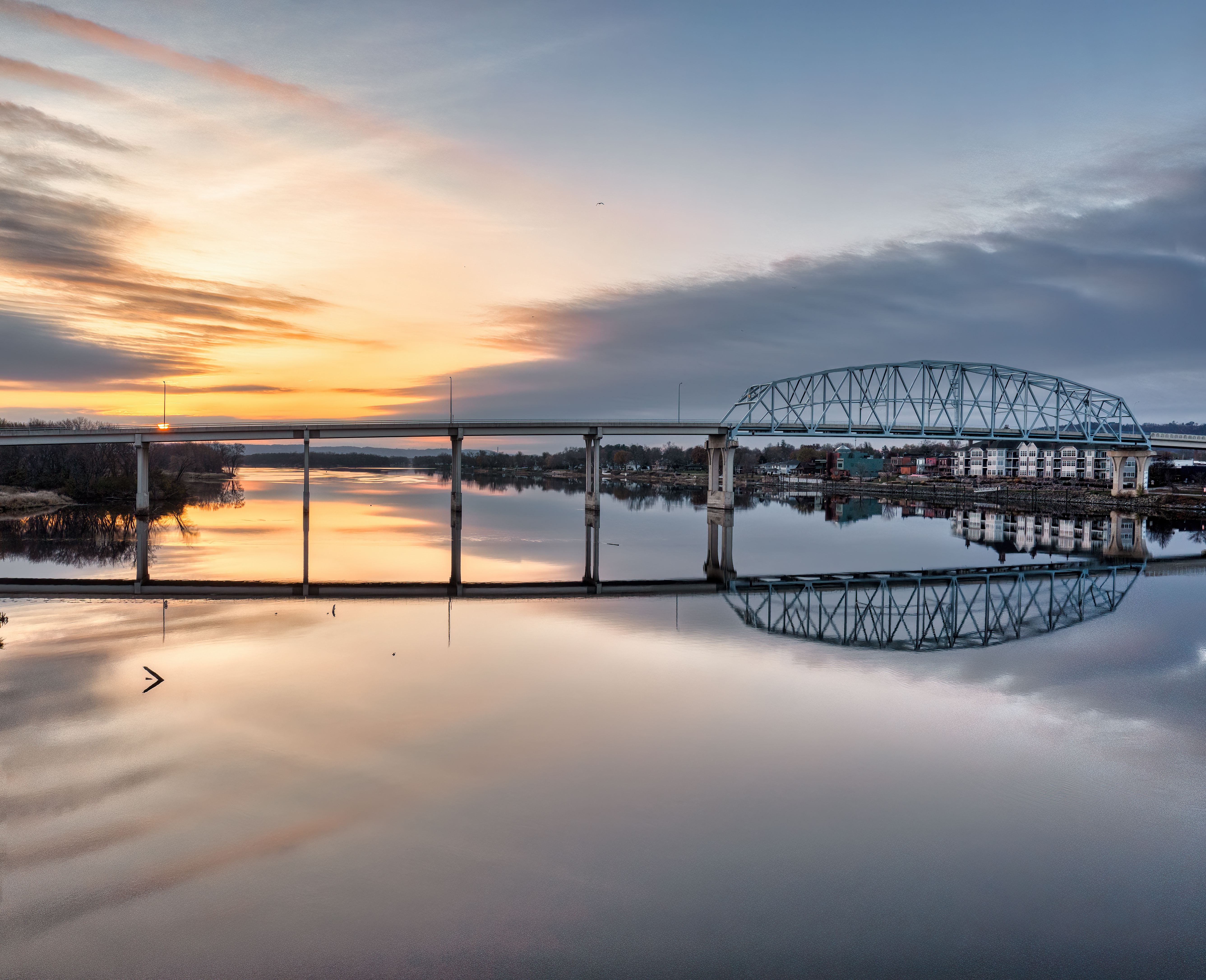 Captivating sunset view of a bridge reflecting on the river in Wabasha, MN.