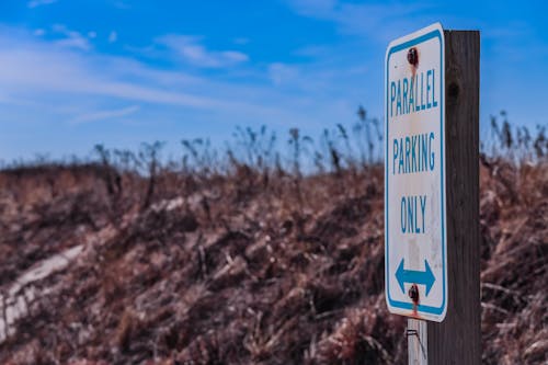 A sign that says fragile parking only on a beach