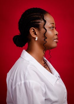 Side profile portrait of a woman against a red background, showcasing elegance and style.