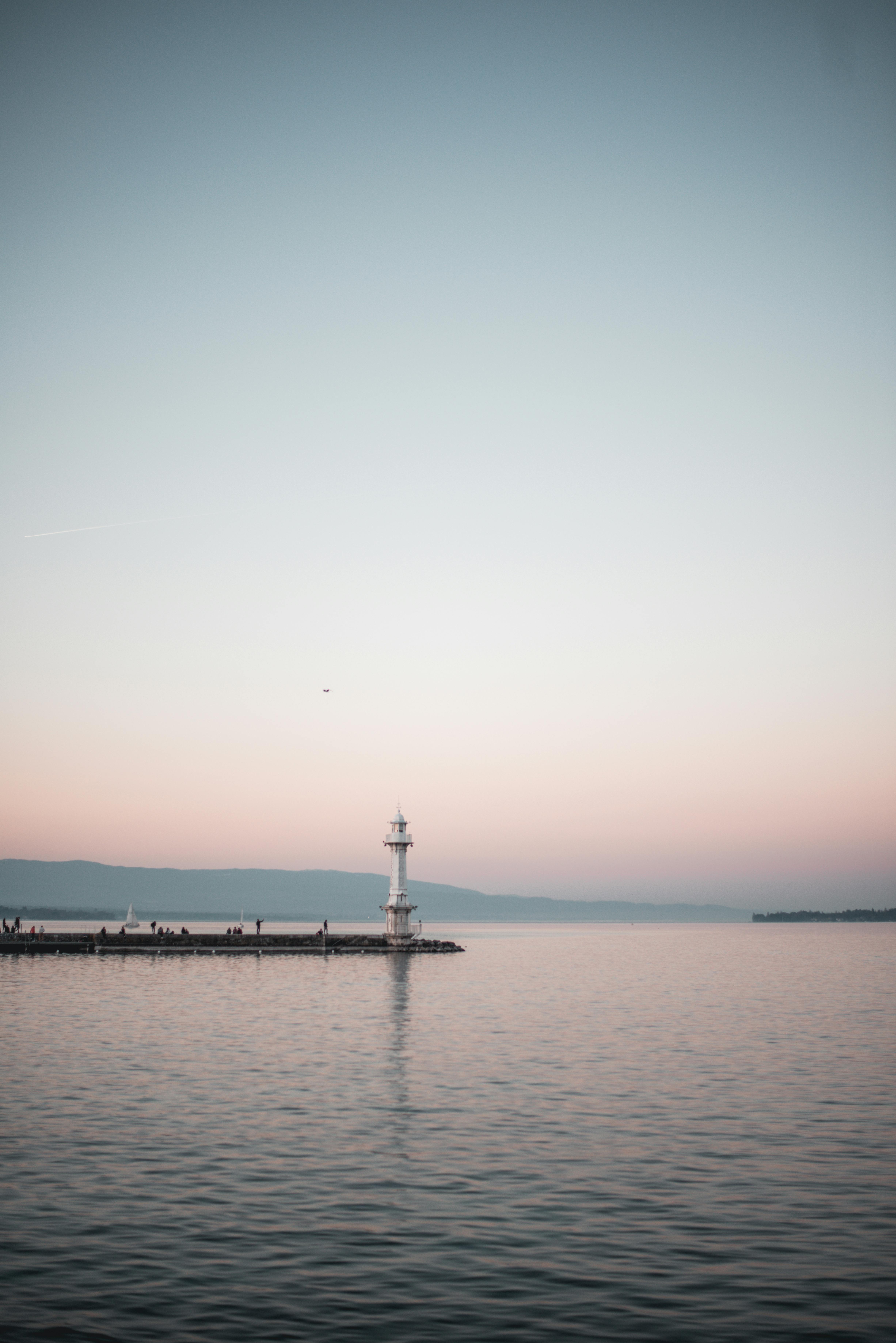 黄昏时分，灯塔映照着宁静的海景，营造出海岸的静谧氛围