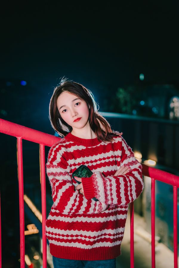 Woman in sweater dress at night in city