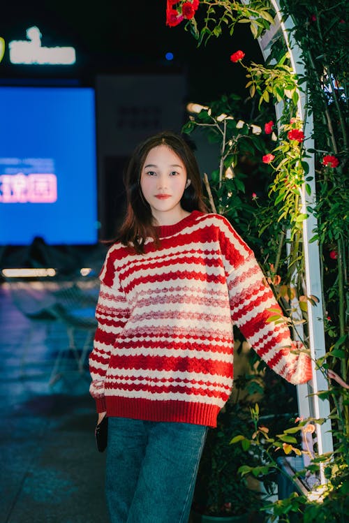 A woman in a red and white sweater posing for the camera