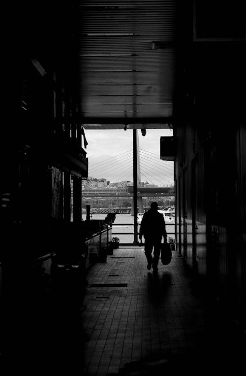 A person is walking down a hallway with a suitcase