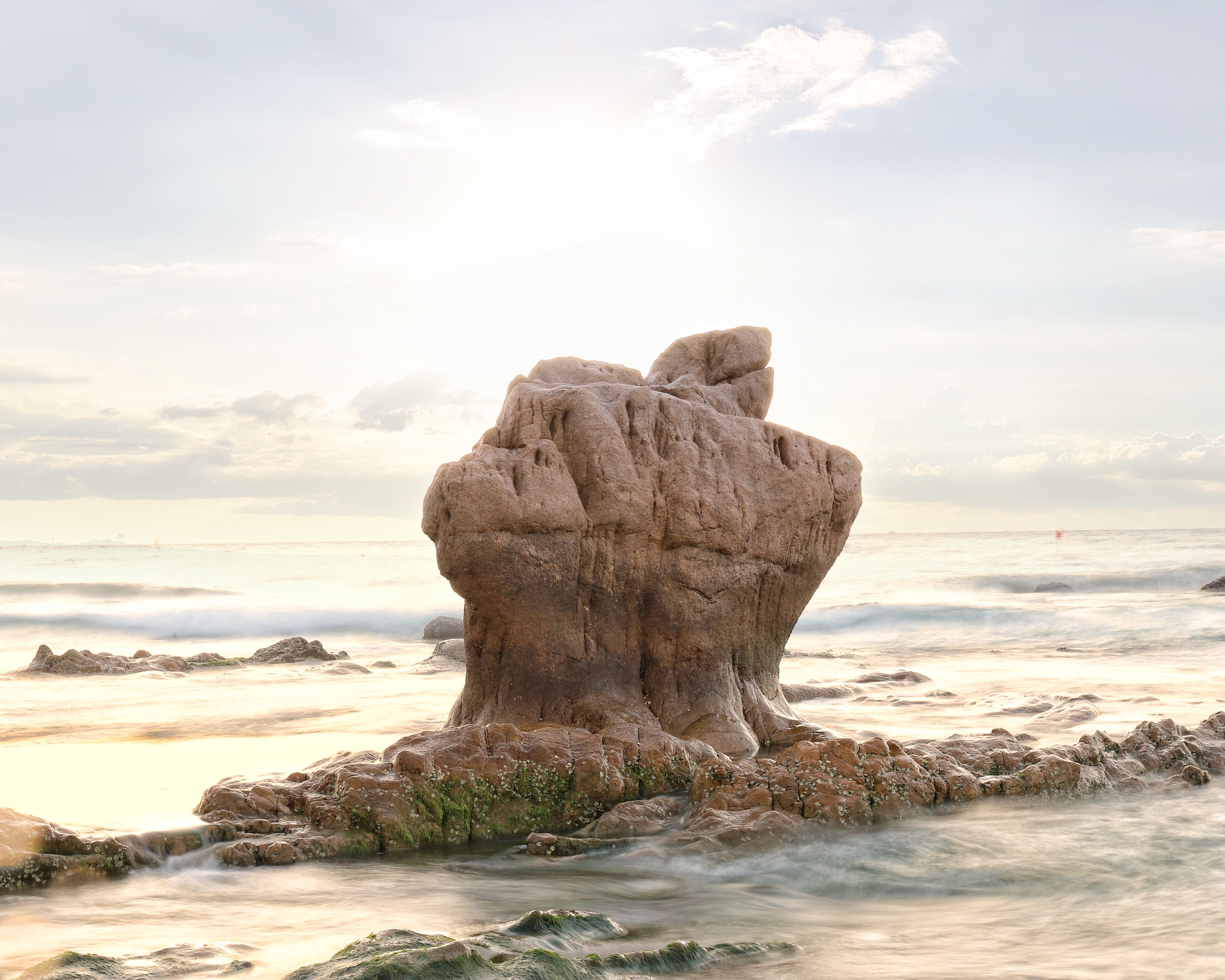 Serene ocean view capturing dawn's light on Bình Thuận's unique rock formation. | BocaVibe
