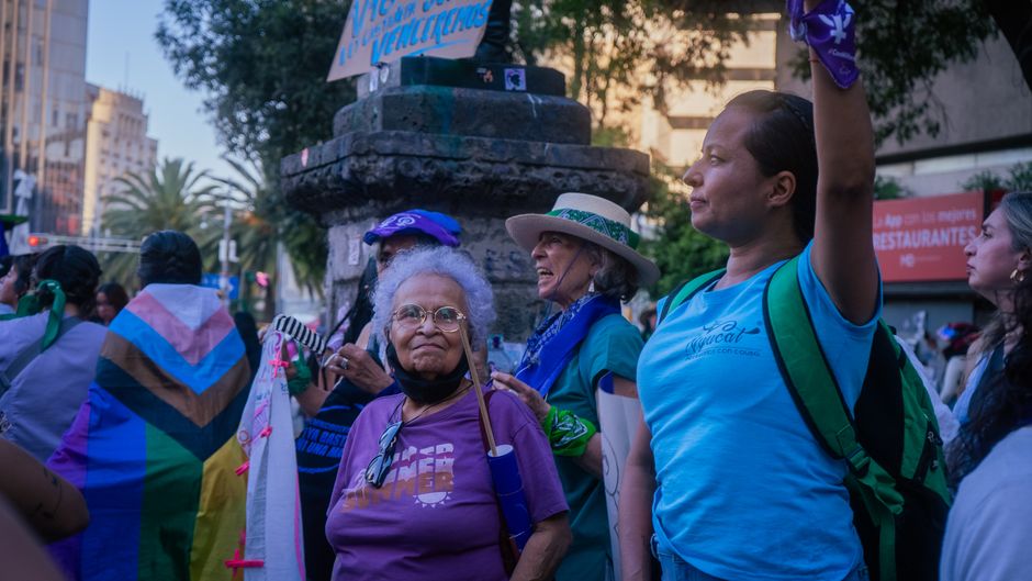 Personas de diferentes edades y orígenes participan en una protesta en la calle.