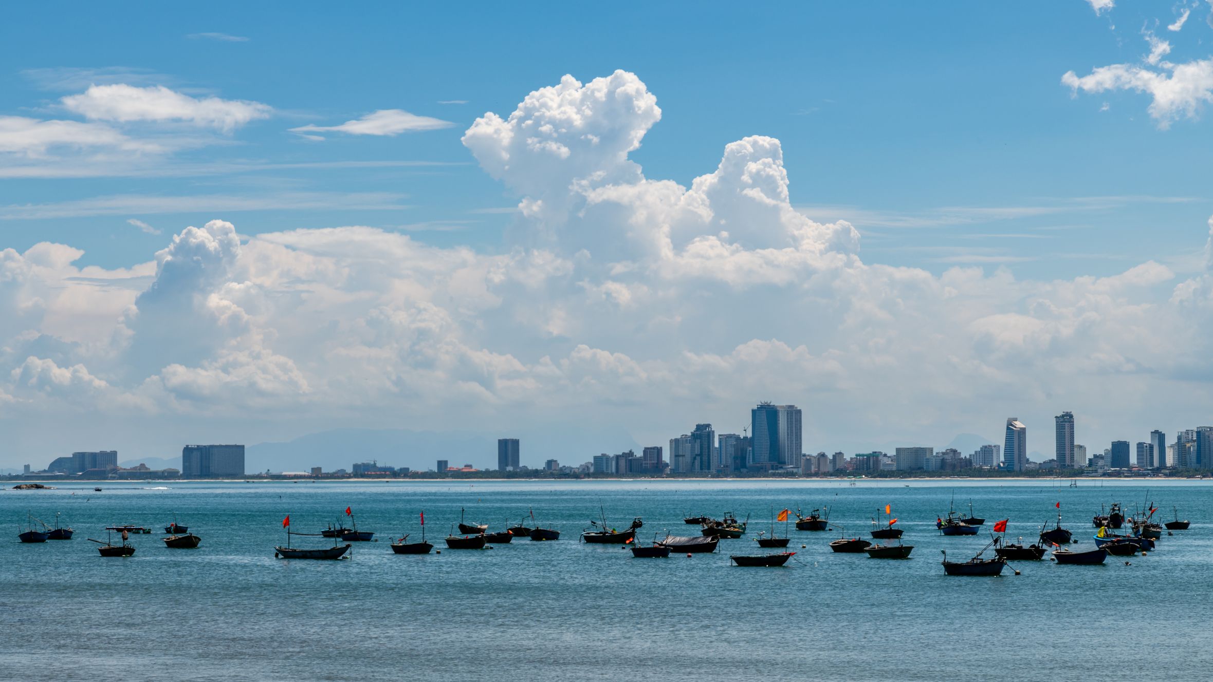 Beautiful view of Da Nang cityscape with boats in the foreground on a sunny day.
