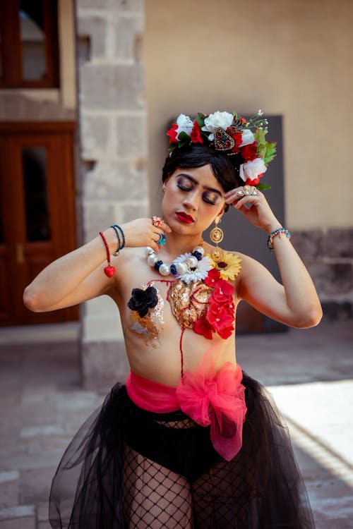 A woman in a black and red outfit with flowers on her chest