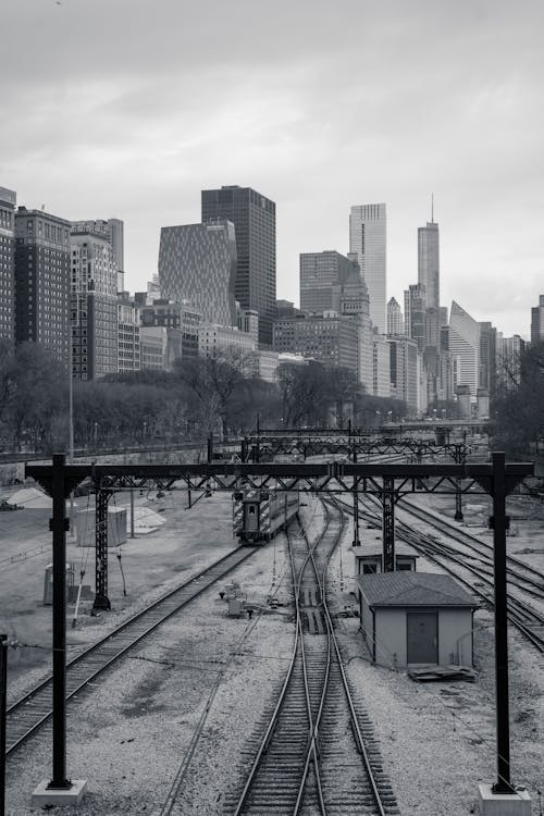 Black and white photo of train tracks and city skyline