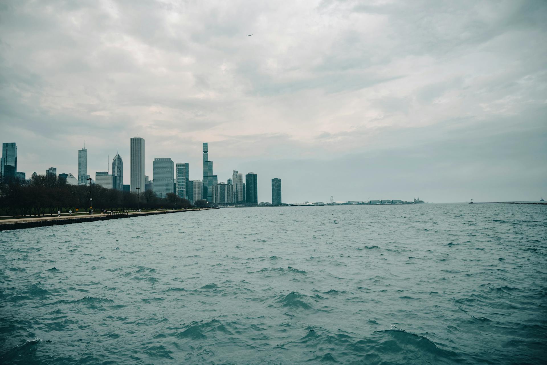 A moody view of the Chicago skyline across Lake Michigan under an overcast sky.