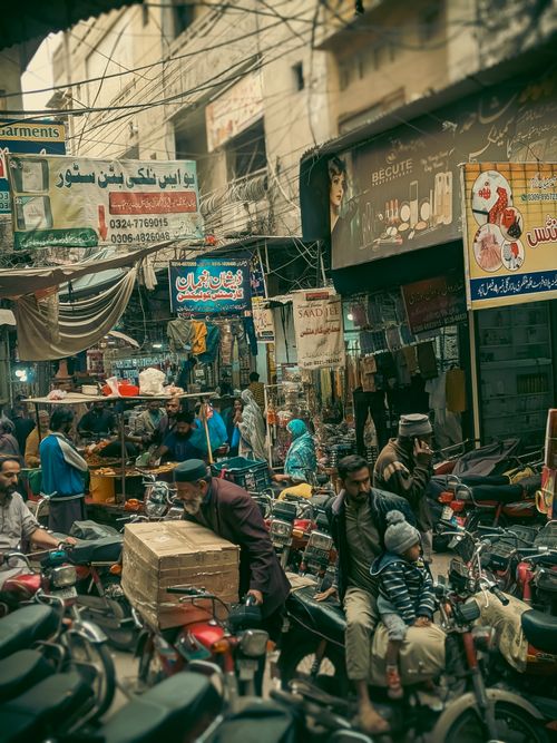 Free Crowded Middle Eastern street with motorbikes, shops, and diverse crowd. Captures vibrant city life. Stock Photo