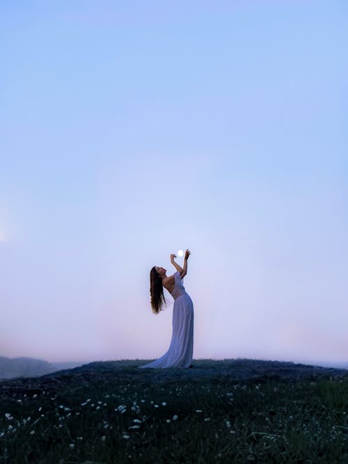 Woman in Dress Posing Against Moon in Clear Sky