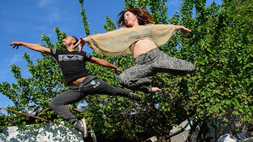 Woman in Black and Grey Pants Beside Man in Black Gap Pants Surrounded by Trees