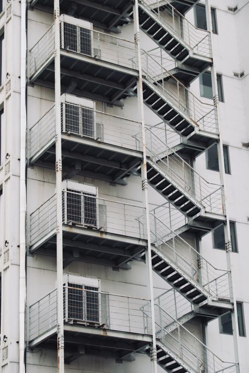 Free Vertical shot of building facade featuring metal outdoor stairs. Stock Photo