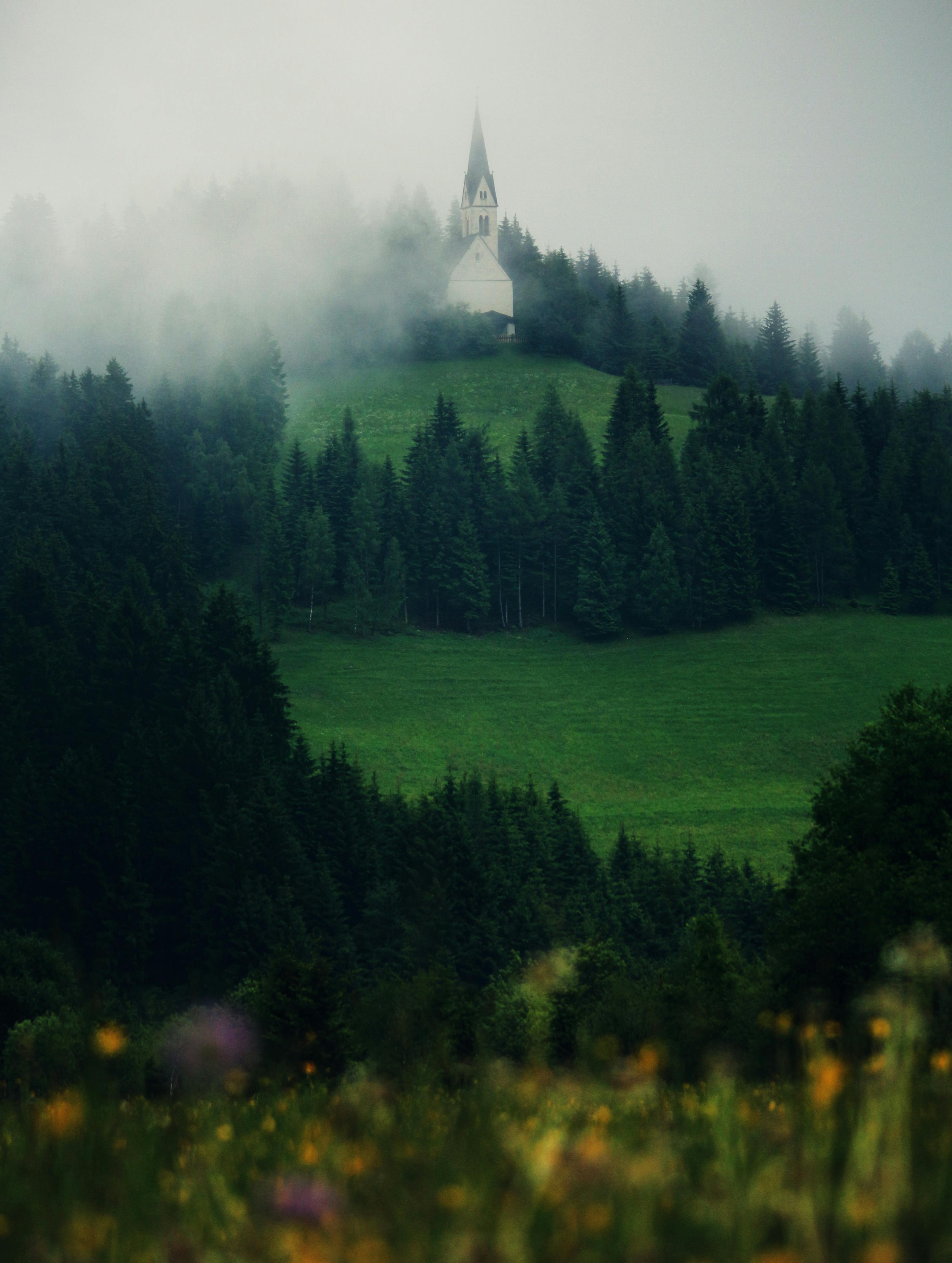 Scenic view of a misty church nestled in the hills of Trentino-South Tyrol.