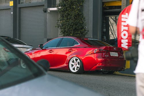 Free Red Sedan Parked Beside Building Stock Photo