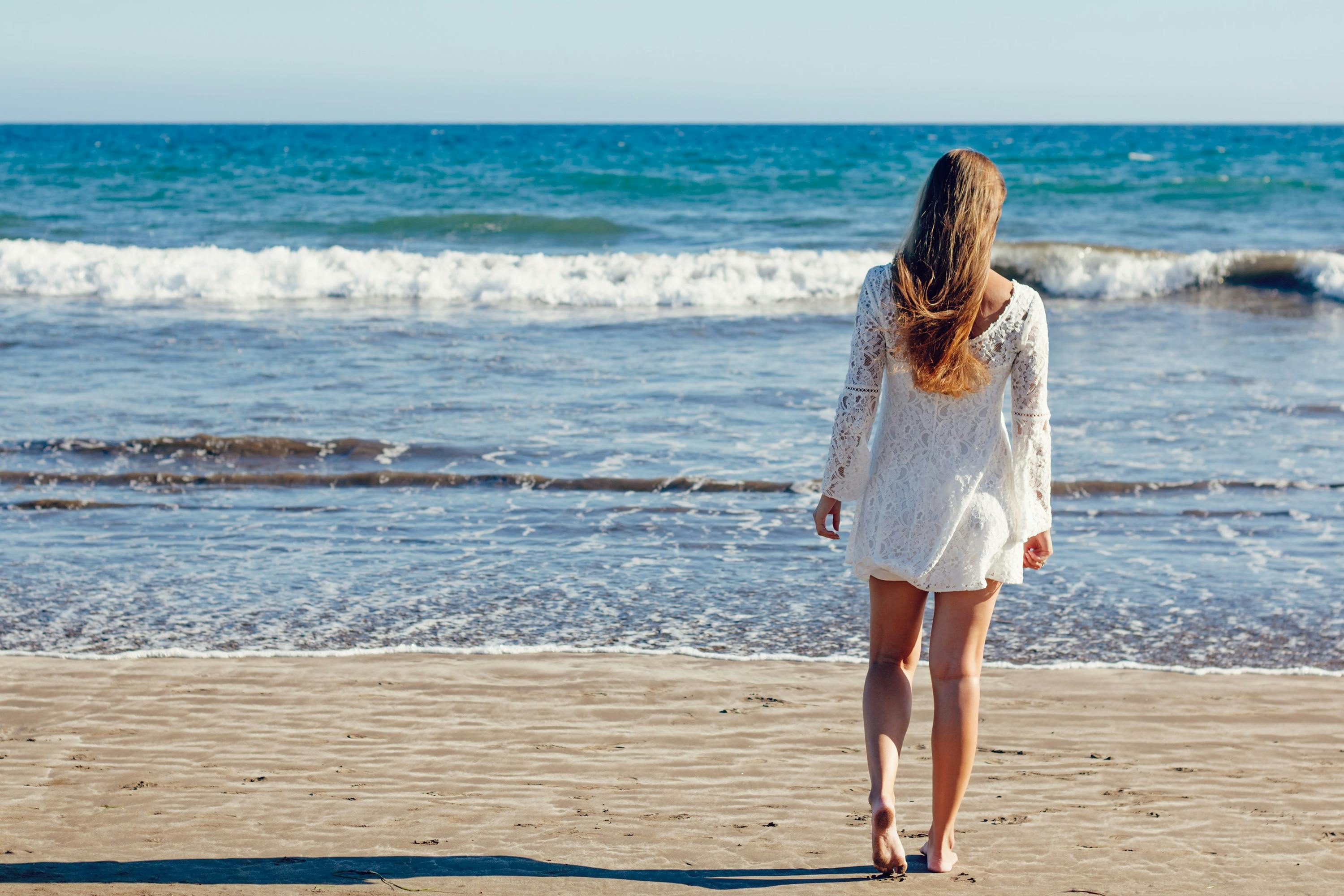 Brown Haired Woman in White Lace Long Sleeve Mini Dress Standing on Seashore \u00b7 Free Stock Photo