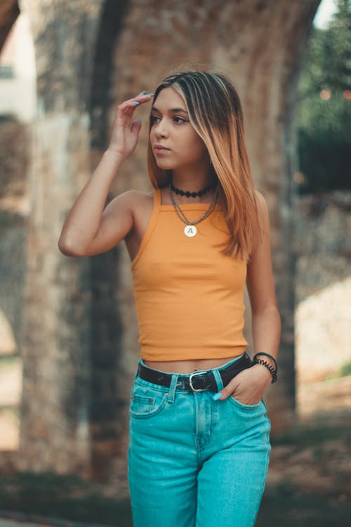 Free Girl Putting Her Left Hand on Her Pocket and Her Right Arm in Front of Her Face Stock Photo