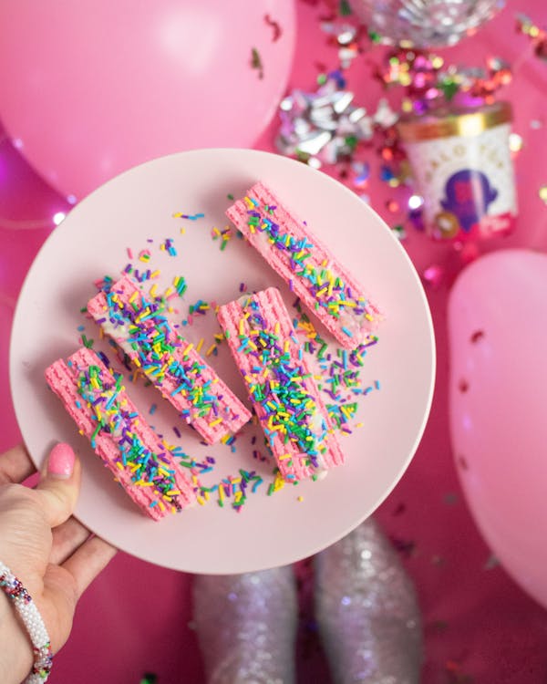 Free Pink Wafer Desert on a Plate held by a Person Stock Photo
