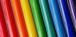 特写镜头中，色彩鲜艳的油漆管被排列成彩虹图案