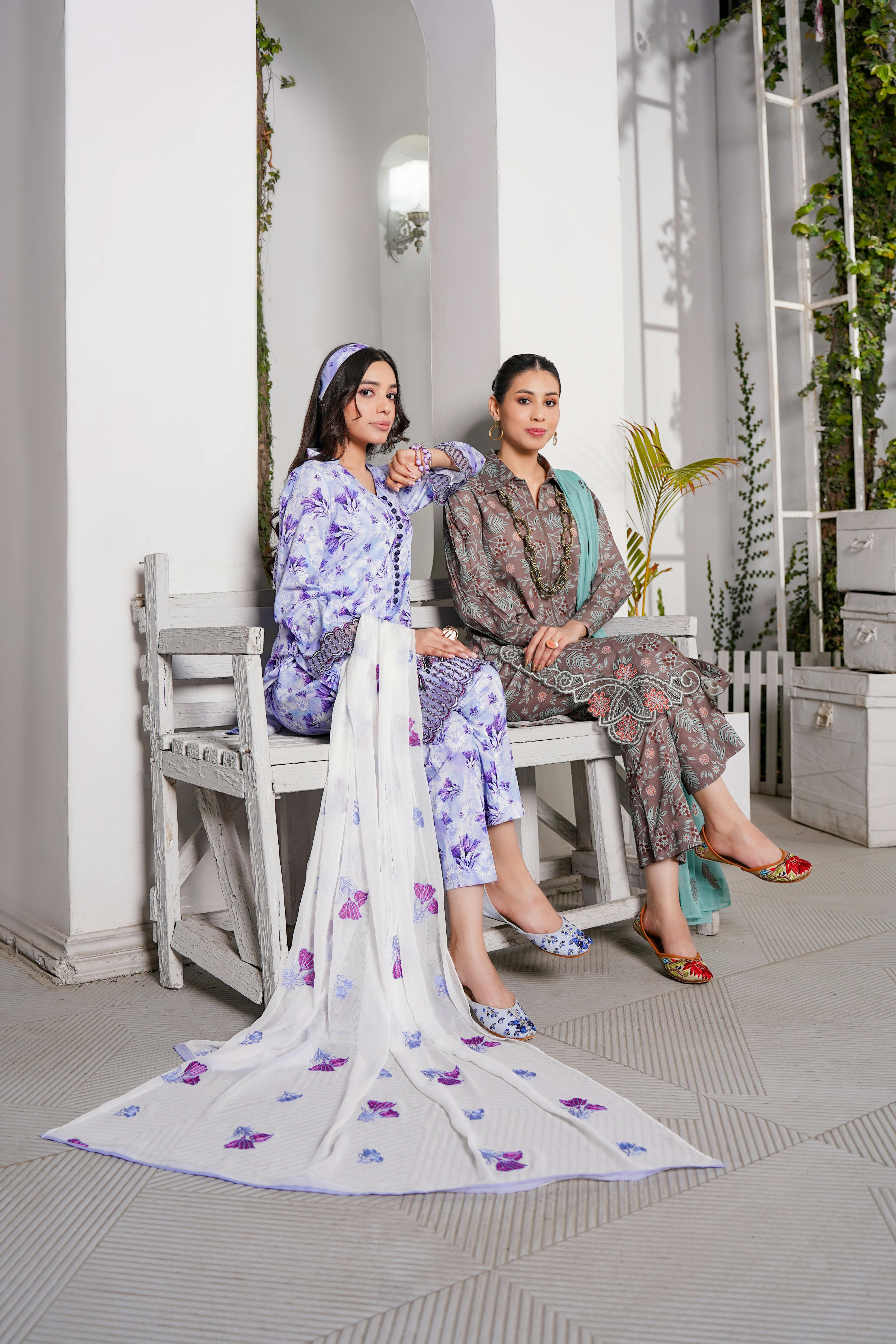 beautiful women in eastern dresses sitting on white bench