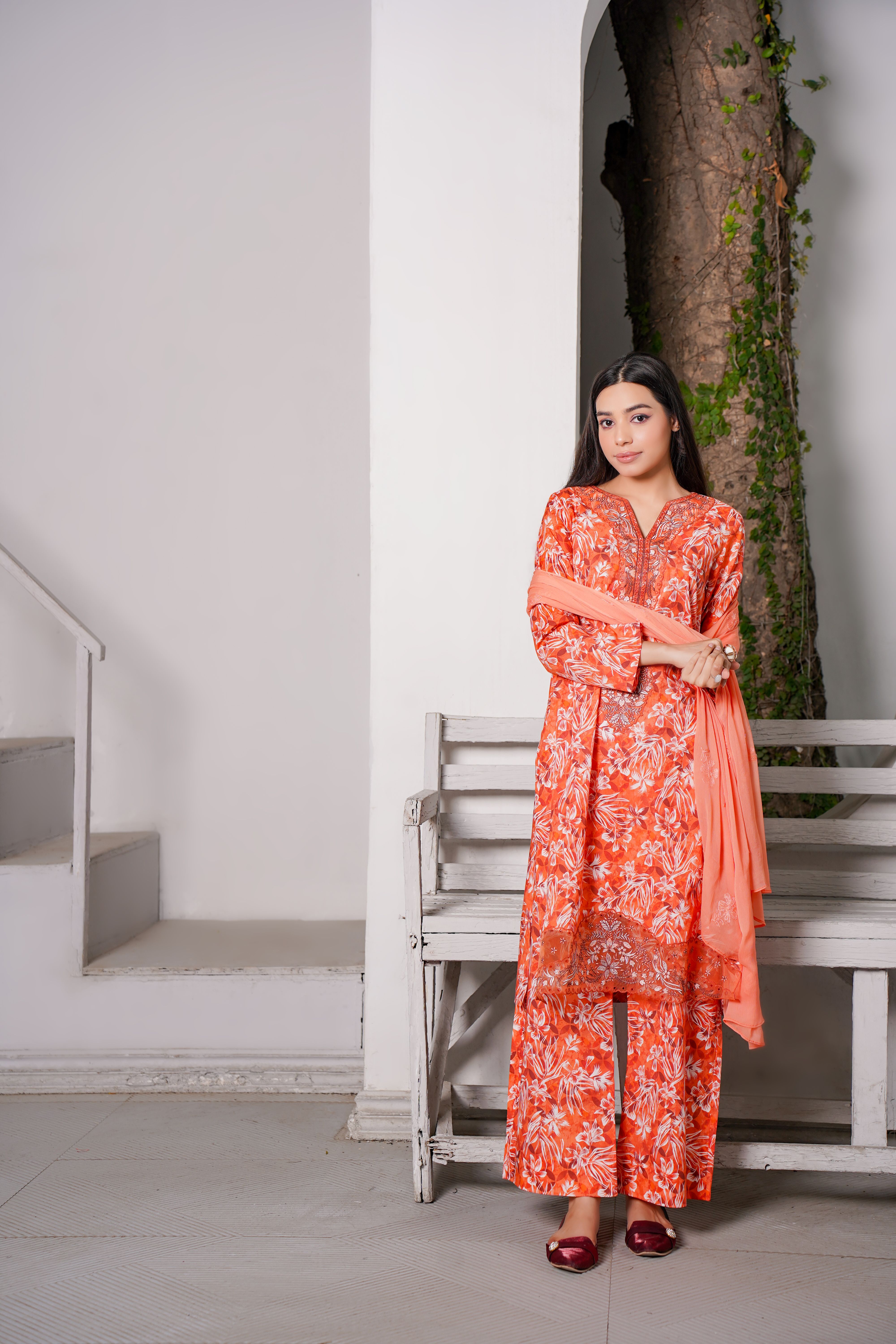 Stylish portrait of a woman in traditional Pakistani attire, standing indoors.