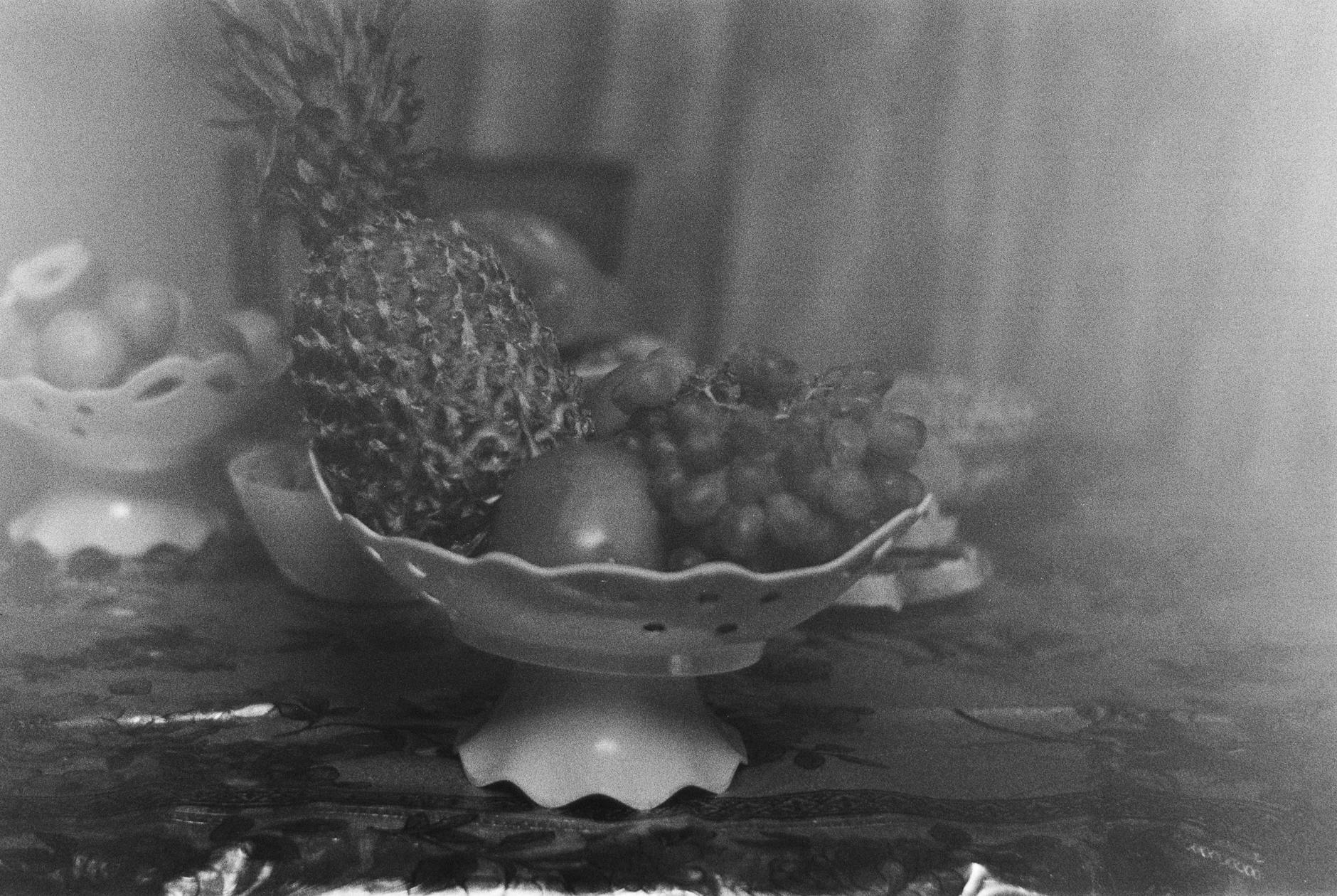 A black and white photograph of fruit in a bowl