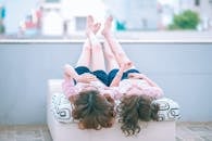 Two Girl Lying on Sofa While Looking Up