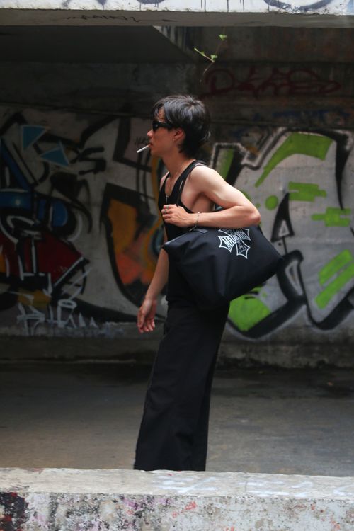 Free Person walking with graffiti art backdrop, showcasing urban lifestyle. Stock Photo