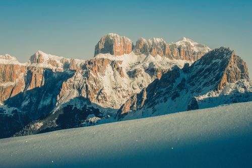Free A breathtaking view of the snow-covered Dolomite mountains under a clear blue sky in winter. Stock Photo