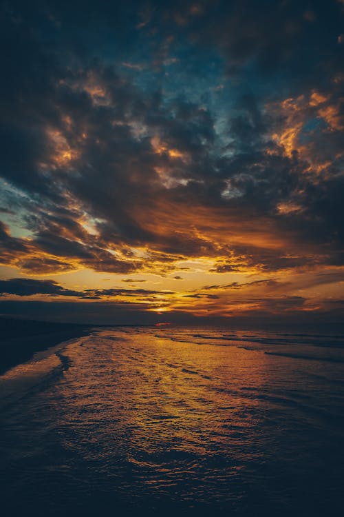 A sunset over the ocean with clouds