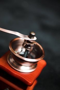 老式咖啡研磨机的金属机构和木制底座的详细视图